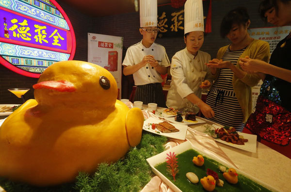 Une pâtisserie en forme de canard, présentée chez Quanjude, un restaurant chinois de Beijing célèbre pour son canard laqué, le 1er septembre 2013. Ces petites gourmandises en forme de canard seront vendues pour 22 Yuans (3,60 Dollars US) la demi-douzaine. Ces canards sont confectionnés à base de citrouille et de riz gluant. Beijing va devenir la deuxième ville de Chine après Hong Kong à exposer le fameux « canard en caoutchouc » de 18 mètres de haut, conçu par l'artiste néerlandais conceptuel Florentijn Hofman, entre le début de septembre et la fin d'octobre. [Photo / Asianewsphoto]