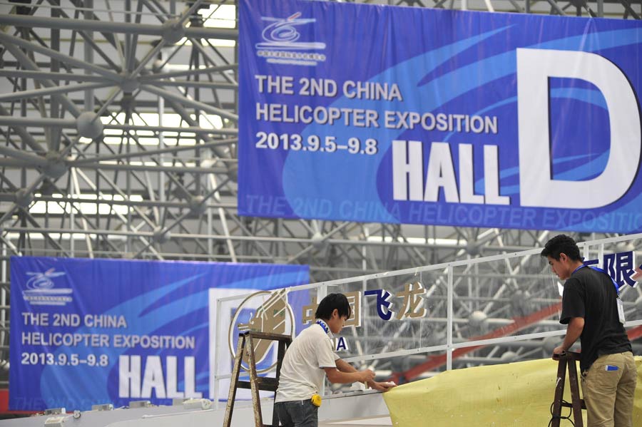 Des ouvriers effectuent les derniers préparatifs pour la 2e Exposition d'Hélicoptères de Chine à Tianjin, le 3 septembre 2013. Plus de 200 entreprises de l'industrie des hélicoptères seront présentes à l'Expo, qui aura lieu du 5 au 8 septembre. [Photo / Xinhua]