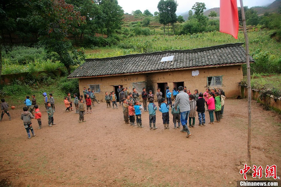 Le 6 septembre 2013 à l'école primaire du village de Naituo, un enseignant s'amuse avec des enfants. (Chinanews/Gao Han)