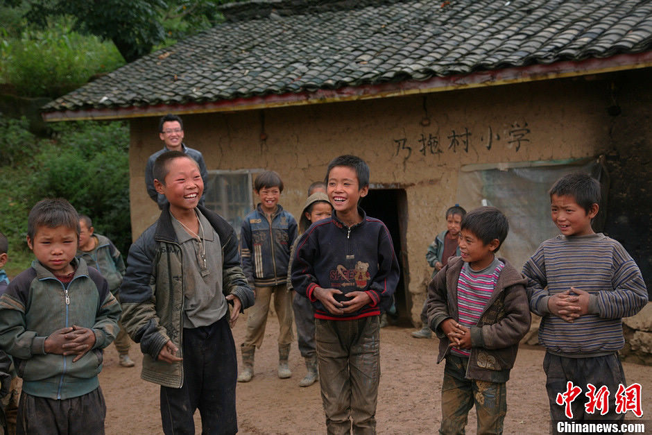 Le 6 septembre 2013 à l'école primaire du village de Naituo, un enseignant s'amuse avec des enfants. (Chinanews/Gao Han)