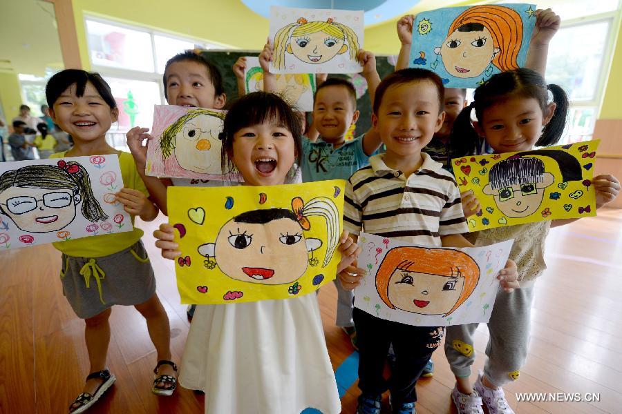 Lundi 9 septembre 2013 dans une école maternelle de Hefei dans la province de l'Anhui, à la veille de la Fête des Enseignants, des enfants dessinent les visages souriants de leurs maîtresses avant de leur en faire cadeau. (Photo : Xinhua/Zhuang Duan)