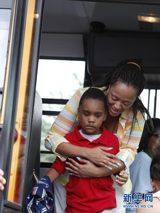 Le 20 août 2013 à Decatur en Georgie aux Etats-Unis, après une fusillade survenue dans une école primaire, la police et les enseignants ont évacué près de 800 élèves. Sur cette image, une maîtresse accompagne un jeune garçon choqué par l'incident. (Photo : Xinhua/Reuters)