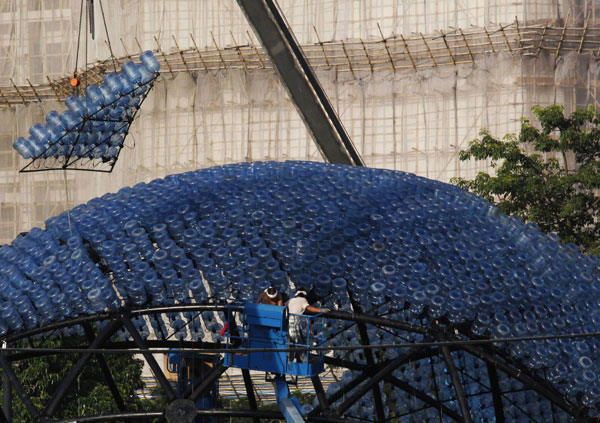 Un segment va être assemblé sur la sculpture qui contiendra 7000 bonbonnes d'eau recyclées avec des lumières LED, mesurant 20 mètres de diamètre et 10 mètres de hauteur, dans le parc Victoria de Hong Kong, le 10 septembre 2013.