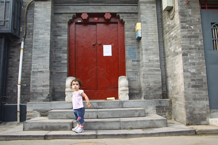 Une fillette devant un siheyuan à Shichahai. [Photo Zou Hong / China Daily]