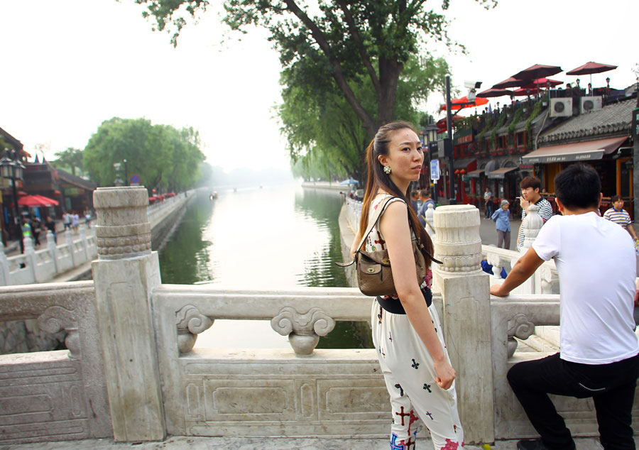 Une femme se promène sur le pont Yindingqiao, qui relie les quartiers de Qianhai et Houhai. [Photo Zou Hong / China Daily]