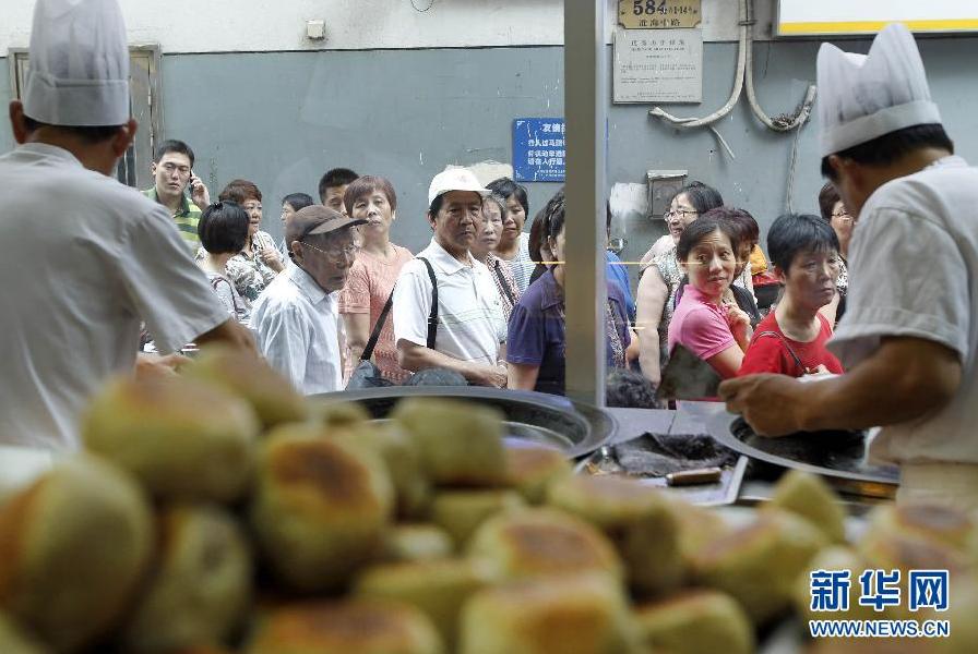 Le 5 septembre, les habitants font la queue devant une boutique de la rue Huaihai à Shanghai pour acheter des gâteaux de lune fabriqués à l'instant.