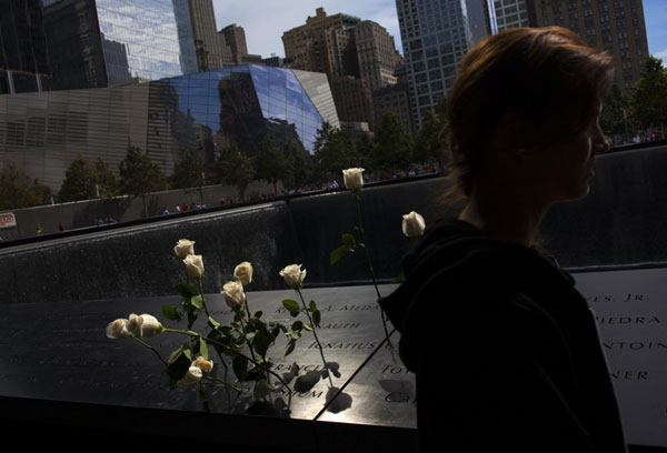 Un visiteur passe devant des roses déposées au Mémorial du 11 septembre, à New York, le 9 septembre 2013. [Photo / agences]