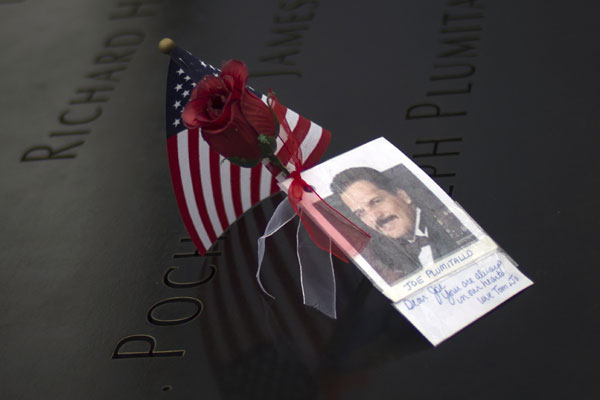 Une rose et une note placées sur un nom inscrit sur le bassin Nord du Mémorial du 11 septembre à Ground Zero, le site des attaques du 11 septembre 2001, à New York, le 10 septembre 2013. [Photo / agences]