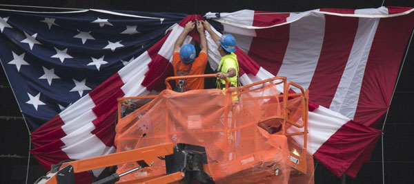 Des ouvriers se préparent à dévoiler le drapeau américain surplombant le Mémorial du 11 septembre à Ground Zero, le site des attaques du 11 septembre 2001, à New York, le 10 septembre 2013. [Photo / agences]