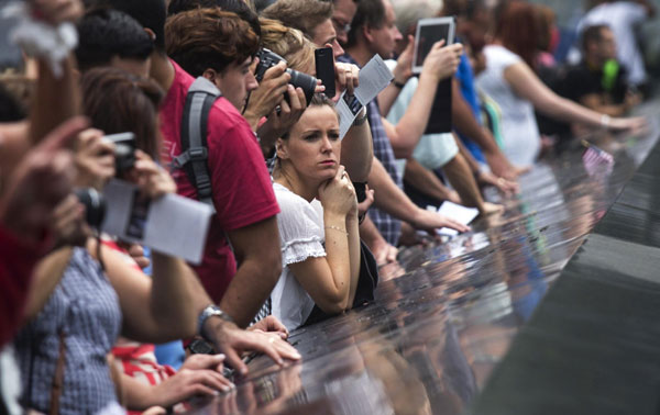 Une femme plongée dans ses réflexions, devant le bassin Sud du Mémorial du 11 septembre à Ground Zero, le site des attaques du 11 septembre 2001, à New York, le 10 septembre 2013. Mercredi marque le 12e anniversaire des attaques du 11 septembre 2001. [Photo / agences]