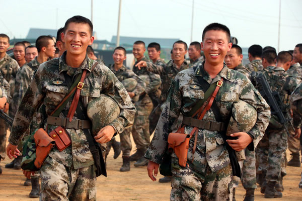 Zhang Dongxu (à gauche), commandant de la compagnie, et Sun Wenlu, instructeur politique de la région militaire de Beijing, coopèrent pour la formation qui a lieu à Shijiazhuang, la province du Hebei au nord de la Chine, le 16 août 2013.