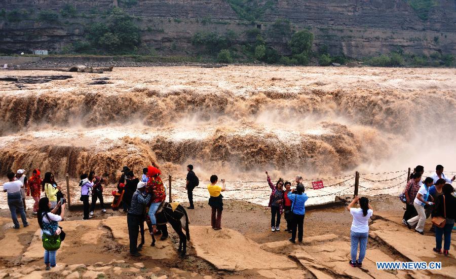 Des touristes photographient la cascade Hukou du fleuve Jaune, située dans le comté de Jixian, la province du Shanxi (nord de la Chine), le 12 septembre 2013. [Photo/Xinhua]