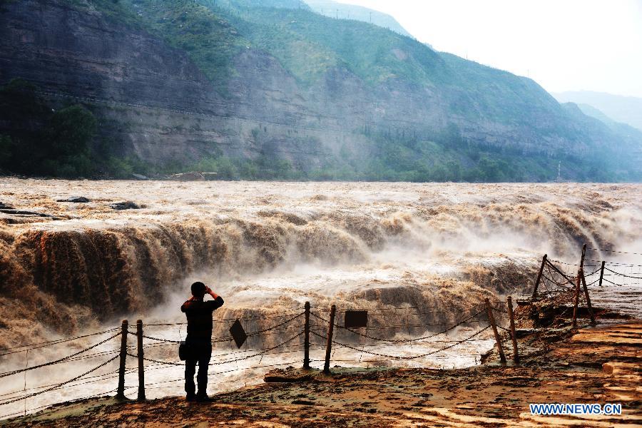 Un touriste immortalise la cascade Hukou du fleuve Jaune, dans le comté de Jixian, la province du Shanxi (nord de la Chine), le 12 septembre 2013. [Photo/Xinhua]