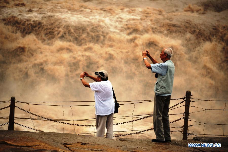 Des touristes prennent des photos de la cascade Hukou du fleuve Jaune, située dans le comté de Jixian, la province chinoise du Shanxi (nord du pays), le 12 septembre 2013. [Photo/Xinhua]