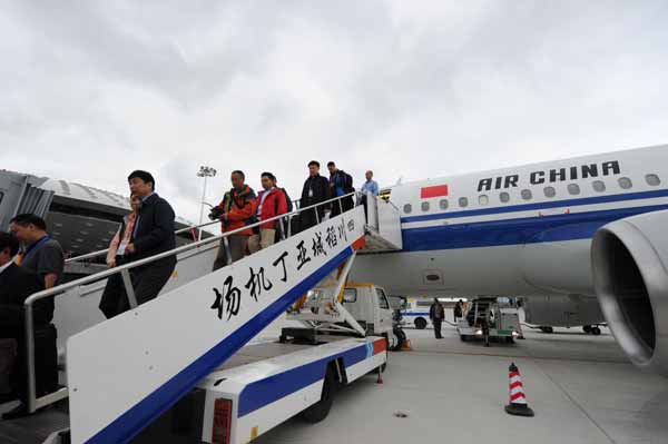 Les visiteurs descendent de l'avion après l'atterrissage du premier vol à l'aéroport Yading de Daocheng, la province du Sichuan (sud de la Chine), le 16 Septembre 2013. 
