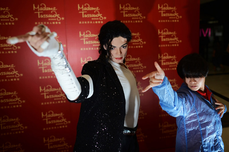 Une fan prend la pause devant le modèle en cire de la pop star Michael Jackson, qui sera destiné à la future branche du musée de cire de Madame Tussauds à Wuhan, la province du Hubei, le 15 septembre 2013.[Photo: Zhou Chao/Asianewsphoto]