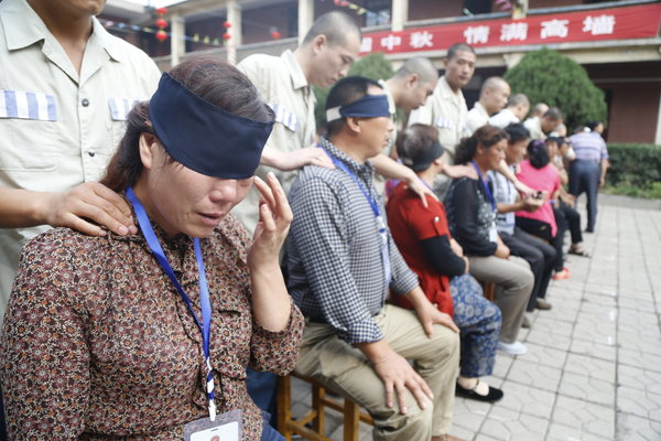 Les policiers aident les membres de la famille des détenus à faire un exercice d'entrainement mental dans la prison de Sanmenxia, dans la Province du Henan, le 17 septembre 2013. [Photo / CFP]
