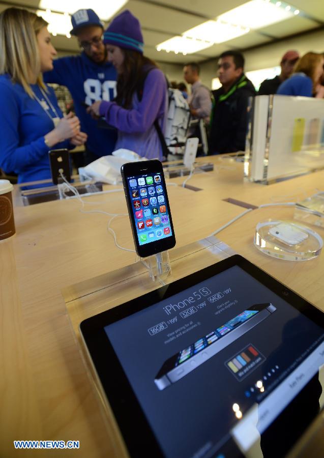Des gens essaient de nouveaux iPhones dans un Apple Store à New York, aux Etats-Unis, le 20 septembre 2013. Les nouveaux iPhone 5C et 5S ont été mis en vente vendredi aux Etats-Unis.