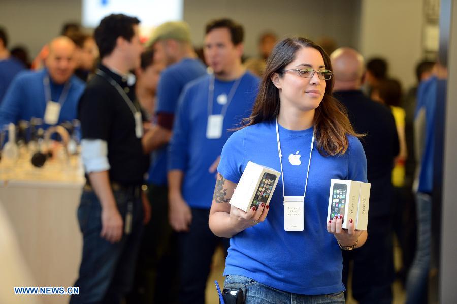 Une employée prépare des iPhones dans un Apple Store à New York, aux Etats-Unis, le 20 septembre 2013. Les nouveaux iPhone 5C et 5S ont été mis en vente vendredi aux Etats-Unis.