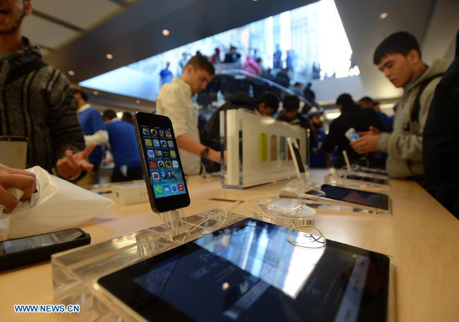 Des gens essaient de nouveaux iPhones dans un Apple Store à New York, aux Etats-Unis, le 20 septembre 2013. Les nouveaux iPhone 5C et 5S ont été mis en vente vendredi aux Etats-Unis.