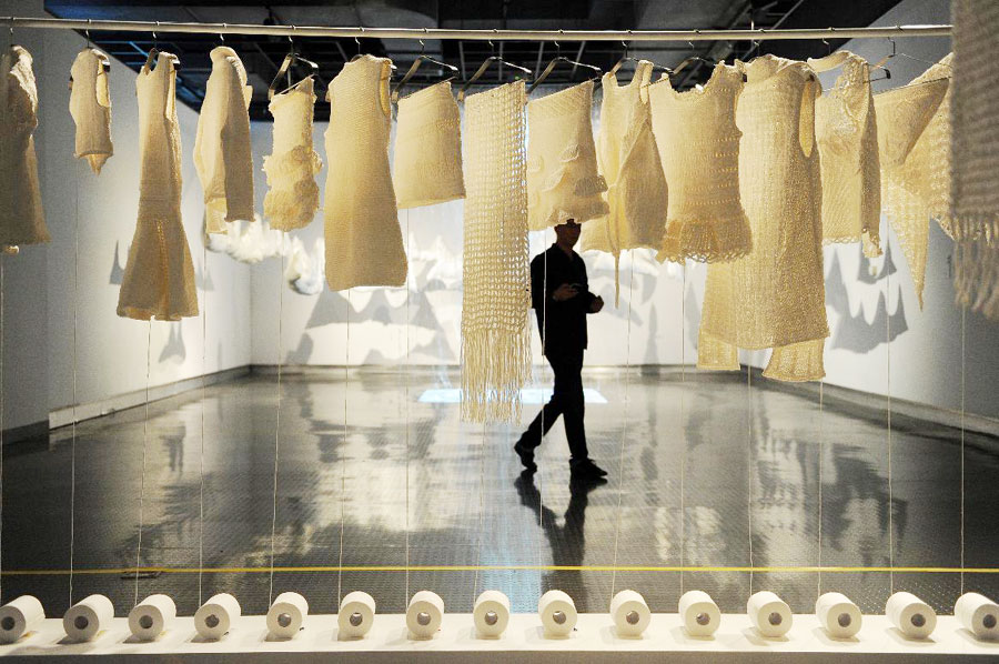 Un jeune homme devant l'œuvre de l'artiste chinois Wang Lei, lors de la 1ère édition de la Triennale des Arts textiles à Hangzhou, capitale de la province du Zhejiang dans l' est de la Chine, le 21 septembre 2013.