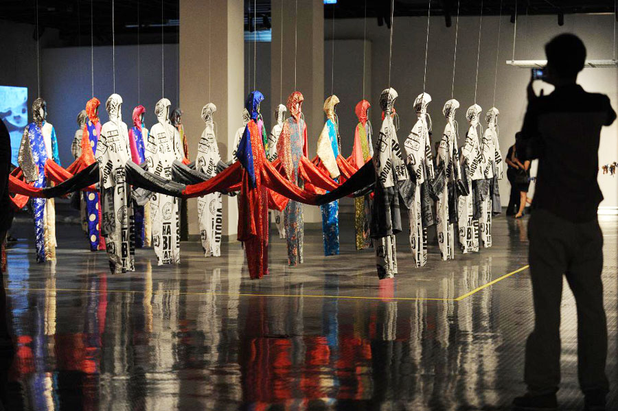 Un visiteur photographie l'oeuvre des artistes français, Lucy et Jorge Orta, lors de la 1ère édition de la Triennale des Arts textiles à Hangzhou, la capitale de la province du Zhejiang (est de la Chine), le 21 septembre 2013.