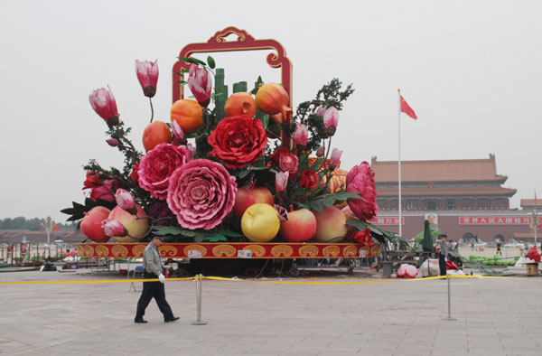 Un policier monte la garde devant une décoration installée en prévision de la Fête Nationale, sur la place Tian'anmen, le 22 septembre 2013. [Photo / Asianewsphoto]