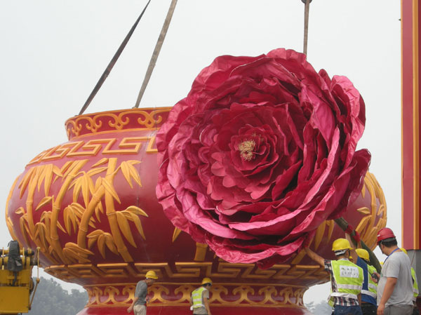 Des ouvriers installent des décorations sur la place Tian'anmen pour célébrer la Fête Nationale, qui aura lieu le 1er octobre à Beijing, le 22 septembre 2013. [Photo / Asianewsphoto]