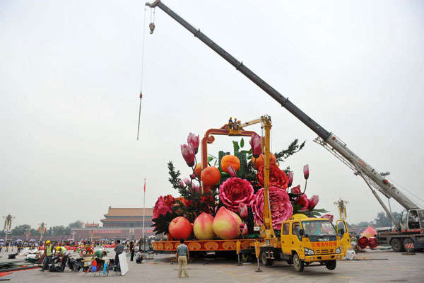 Des ouvriers installent des décorations sur la place Tian'anmen pour célébrer la Fête Nationale, qui aura lieu le 1er octobre à Beijing, le 22 septembre 2013. La décoration en forme de panier fait 18,2 mètres de haut et 15 mètres de diamètre. [Photo / Xinhua]