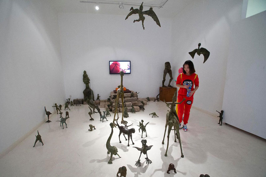 Une jeune Chinoise devant plusieurs sculptures lors de l'édition 2013 du Festival 798 Art à Beijing, la capitale de la Chine, le 21 septembre. Ce festival annuel a débuté samedi, au 798 Art District, avec près de 100 événements artistiques. 