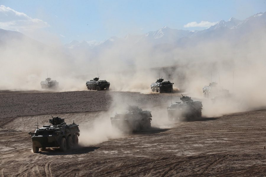 Des véhicules blindés à pleine vitesse sur la région du plateau dans la Région autonome ouïgoure du Xinjiang, dans le cadre d'exercices militaires, le 6 septembre 2013. [Photo / Xinhua]