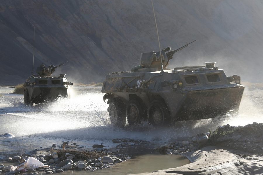 Des véhicules blindés traversent un cours d'eau pendant un entraînement militaire sur la région du plateau dans la Région autonome ouïgoure du Xinjiang, le 7 septembre 2013. [Photo / Xinhua]