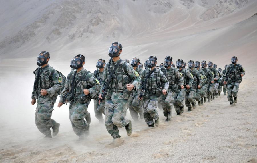 Des soldats chinois portant des masques à gaz prennent part à un entraînement militaire sur la région du plateau dans la Région autonome ouïgoure du Xinjiang, le 5 septembre 2013. [Photo / Xinhua]