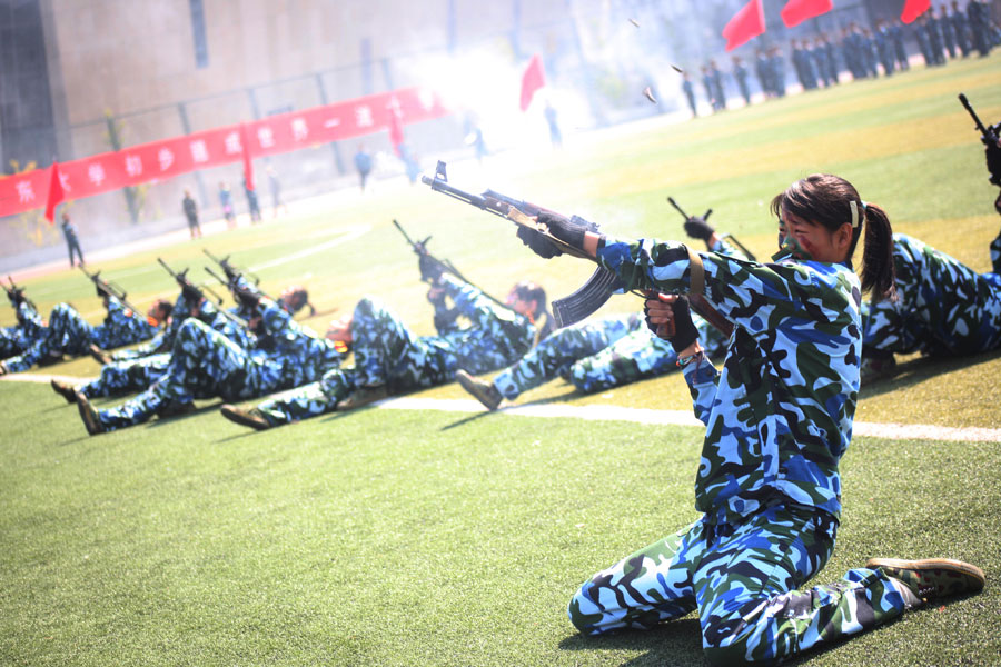 Des étudiantes universitaires armées de fusils d'assaut font montre de leurs compétences lors d'un show militaire à l'Université du Shandong, à Jinan, dans la Province du Shandong en Chine de l'Est, le 26 septembre 2013. [Photo Zheng Tao / Asianewsphoto]