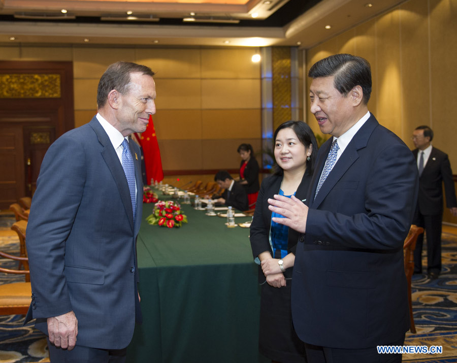 Le président chinois Xi Jinping (D) et le Premier ministre australien Tony Abbott se sont mis d'accord dimanche à Bali en Indonésie pour promouvoir les relations bilatérales et accélérer les négociations sur le libre échange.