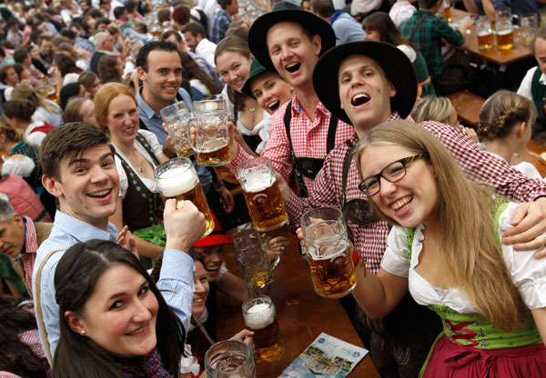 Des visiteurs en provenance de Londres, une chope de bière à la main, lors de la dernière journée de la fête de la bière, à l'occasion de la 180e édition de la Oktoberfest à Munich, le 6 octobre 2013. Des millions d'amateurs de bière venant du monde entier se sont retrouvés dans la capitale bavaroise au cours des deux dernières semaines. [Photo/agences]