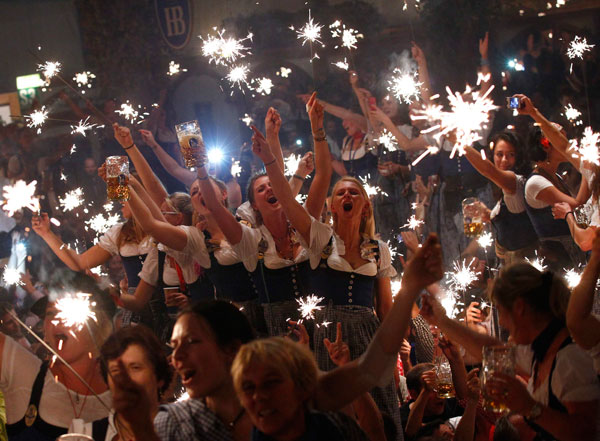Les serveuses de la Oktoberfest en fête avec les cierges magiques, marquant la fin du plus grand festival de bière au monde, lors de la 180e édition de la Oktoberfest, à Munich, le 6 octobre 2013. [Photo/agences]