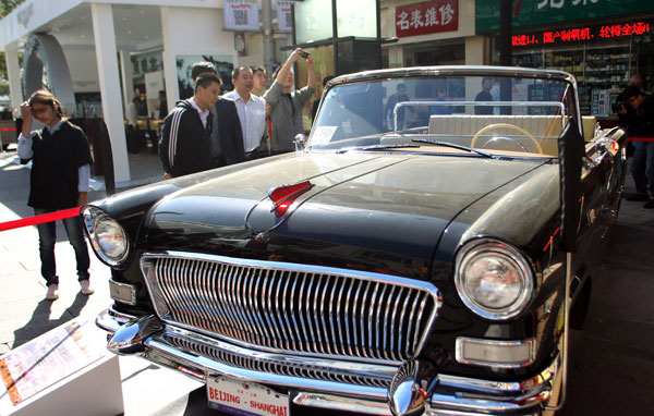 Les visiteurs prennent des photos d'une voiture de marque, lors d'une exposition de voitures anciennes dans la rue Wangfujing à Beijing, le 10 octobre. (Photo : Zou Hong/China Daily)