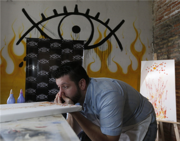 L'artiste Leandro Granato giclées de peinture de son oeil sur une toile dans son atelier de la ville Alejandro Korn plus Buenos Aires Octobre 10 2013. Leandro Granato peint en utilisant une technique unique qui consiste à prendre dans la peinture à travers son nez et l'injecter à travers les yeux sur une toile. Leandro Granato envoie à chaque client de ses œuvres une vidéo qui montre comment il a fait la peinture qu'ils ont achetée, et explique que les peintures qu'il utilise sont inoffensives pour ses yeux.