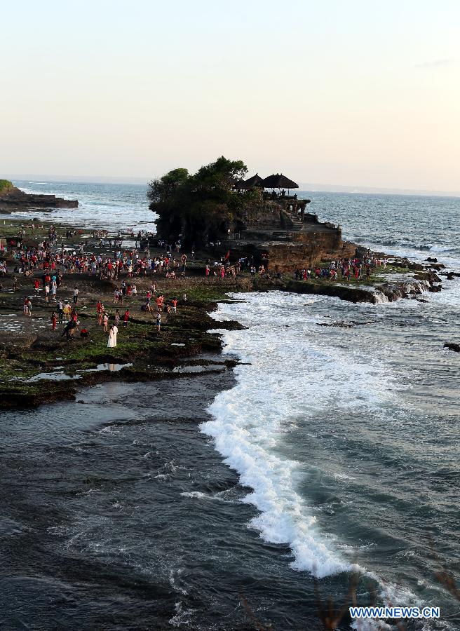 Photo prise le 5 octobre 2013 montrant des touristes qui visitent le Tanah Lot à Bali, en Indonésie. (Xinhua/Li Peng)