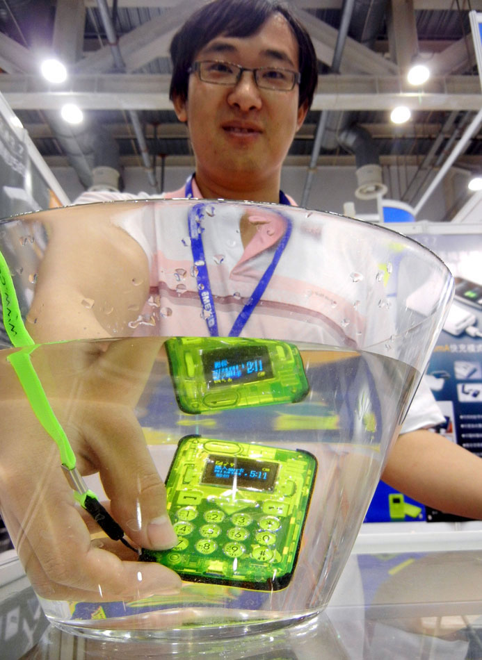 Un membre du personnel de l'exposition présente un smartphone étanche lors de la 12e Exposition de fabricants de produits électroniques de Chine à Suzhou, qui se tient pendant cinq jours à Suzhou, dans la Province du Jiangsu, mercredi.