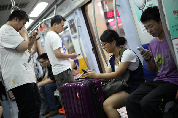 Des gens tuent le temps avec leurs téléphone portable pendant un trajet dans le métro à Beijing, le 31 août 2013.