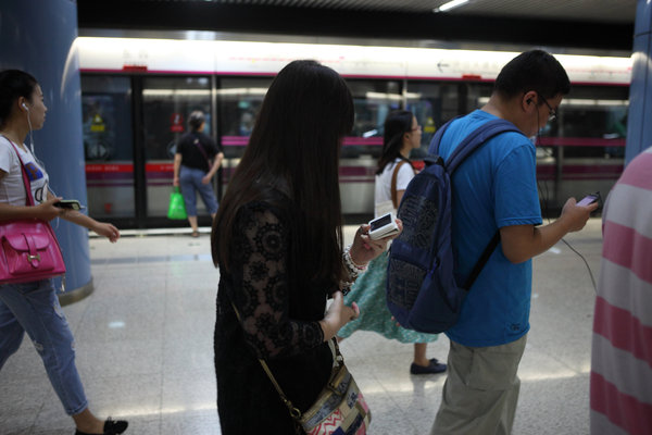 Ils sont nombreux à scruter l'écran de leurs mobiles, tout en marchant dans le métro à Beijing le 31 août 2013.