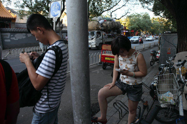 Le portable est devenu indispensable, dans les rues de Beijing , le 30 août 2013.