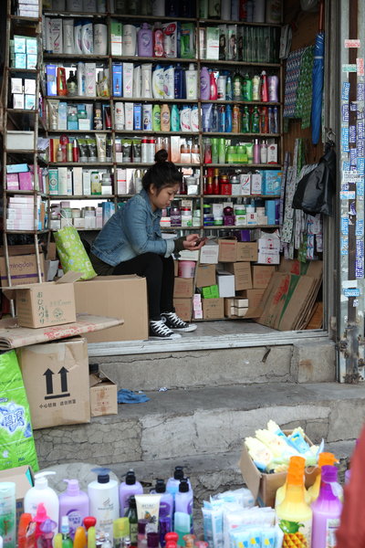 Une vendeuse joue avec son téléphone portable dans un marché de Shenyang, dans la province du Liaoning ( nord de la Chine), le 9 octobre 2013 .