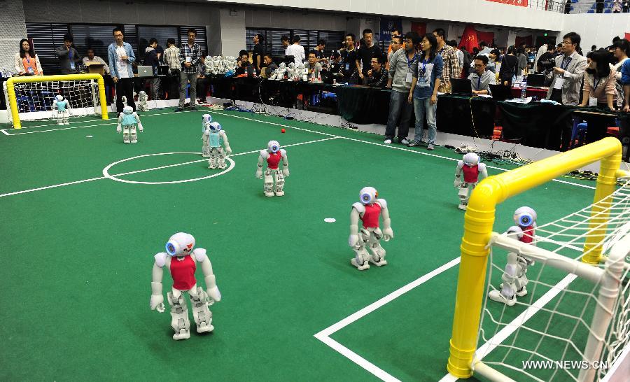 Des Robots en plein match, à l'occasion de la compétition 2013 des robots chinois et de la China Robocup, dans la province de Hefei, à Anhui, le 19 octobre 2013. [Photo/Xinhua]