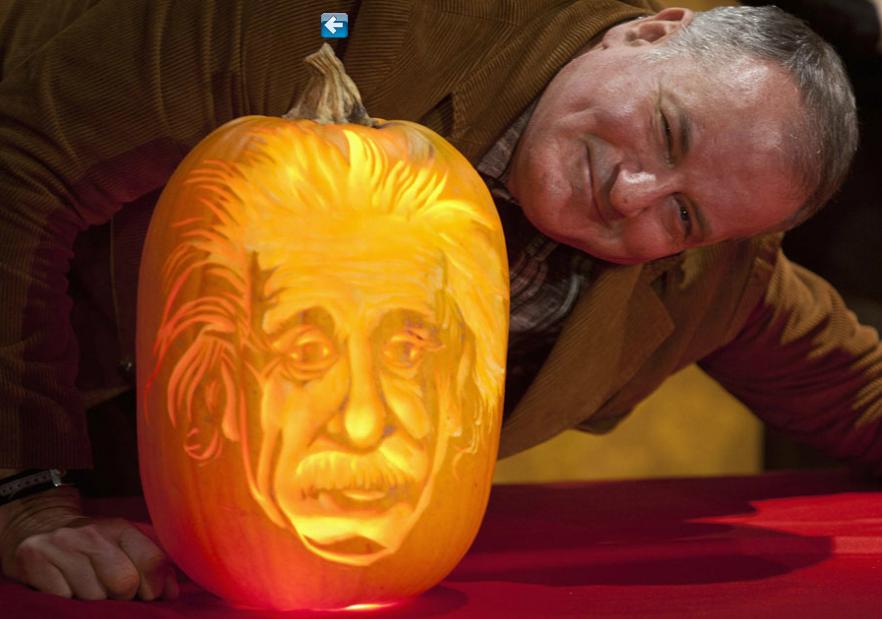 L'artiste Hugh McMahon aux côtés de la citrouille d'Albert Einstein, qu'il a sculptée pour le musée Madame Tussauds à New York, le 22 octobre 2013. 