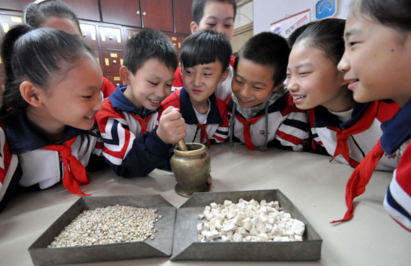 Des élèves de l'école primaire Zhuhelu de Handan essayent de broyer des médicaments à la pharmacie du deuxième Hôpital de Handan, dans la ville de Handan, province du Hebei, le 21 octobre 2013. [Photo Hao Qunying / Asianewsphoto]