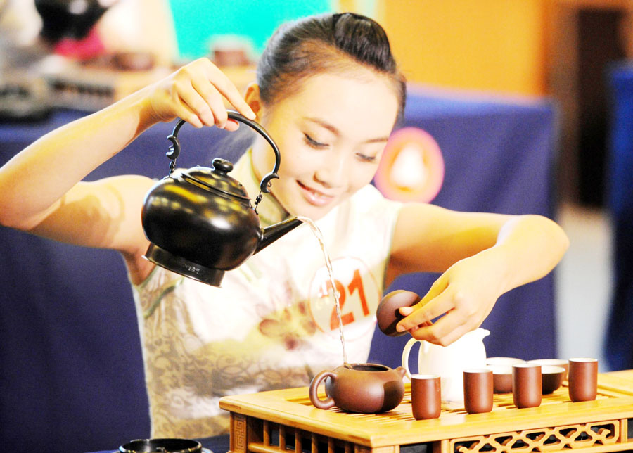 Une compétitrice fait montre de ses talents lors du 2e concours national d'adresse de dégustation du thé à Wuyi, dans la Province du Zhejiang, le 22 octobre 2013. 169 personnes ont participé à cette compétition de 2 jours. [Photo / Xinhua] 