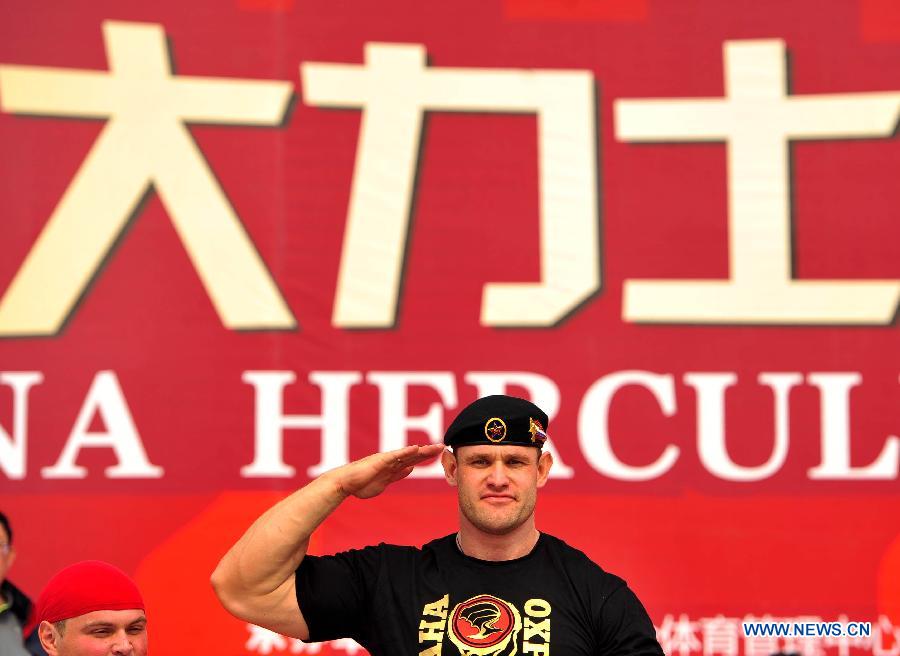 Le 24 octobre 2013 devant l'entrée des studios de cinéma de Xiangyang dans la province du Hubei, le champion du China Hercules Open 2013 Mikhail Shivlyakov pose sur le podium. (Photo : Xinhua/Xiao Yijiu)